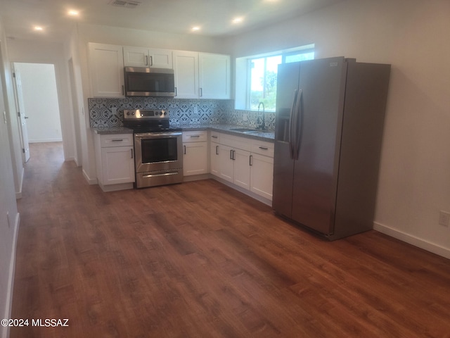 kitchen with appliances with stainless steel finishes, sink, white cabinets, and dark hardwood / wood-style flooring