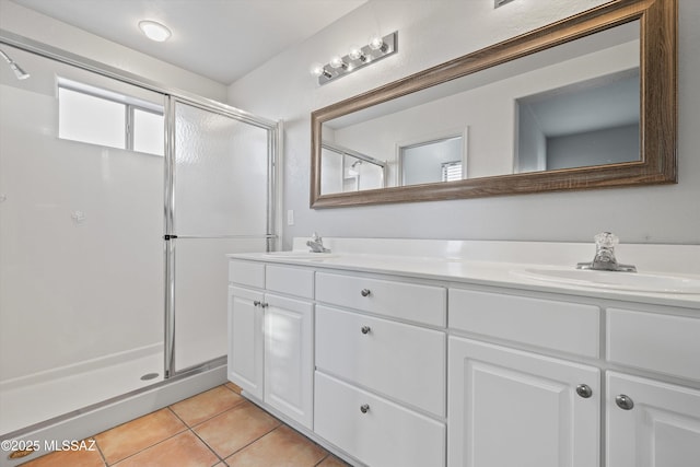 bathroom with tile patterned floors, vanity, and a shower with door