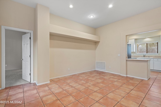 unfurnished room with light tile patterned floors and sink