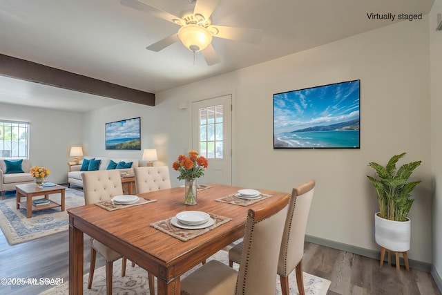 dining space featuring beam ceiling, ceiling fan, a wealth of natural light, and hardwood / wood-style flooring