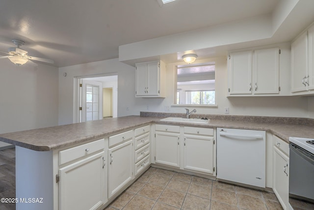 kitchen with white appliances, white cabinetry, sink, kitchen peninsula, and ceiling fan