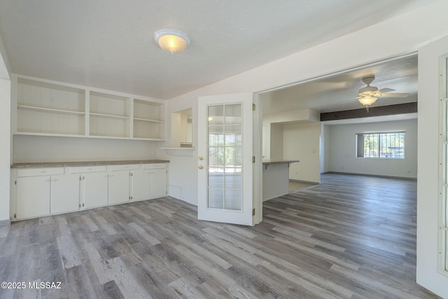 kitchen featuring a textured ceiling, ceiling fan, light hardwood / wood-style flooring, and white cabinets