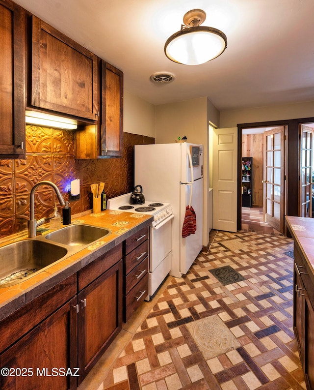 kitchen with backsplash, white range oven, and sink