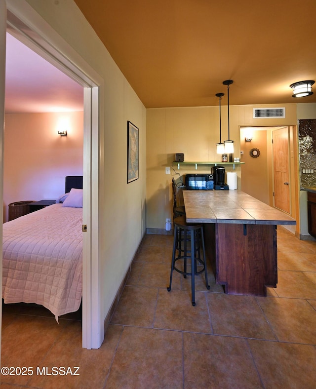 kitchen featuring a breakfast bar area, kitchen peninsula, and decorative light fixtures