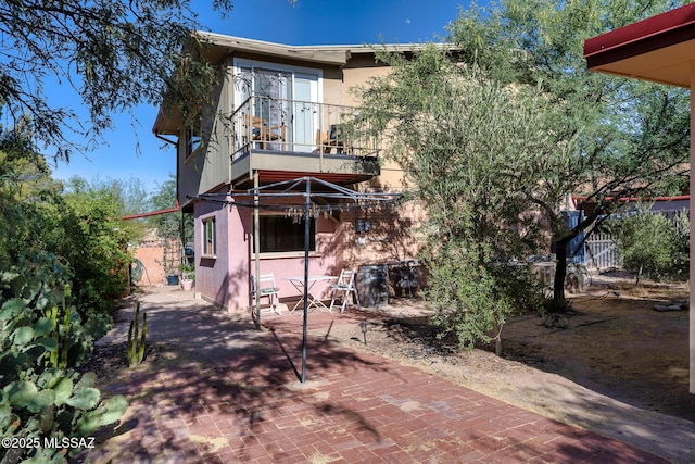 rear view of house with a patio and a balcony