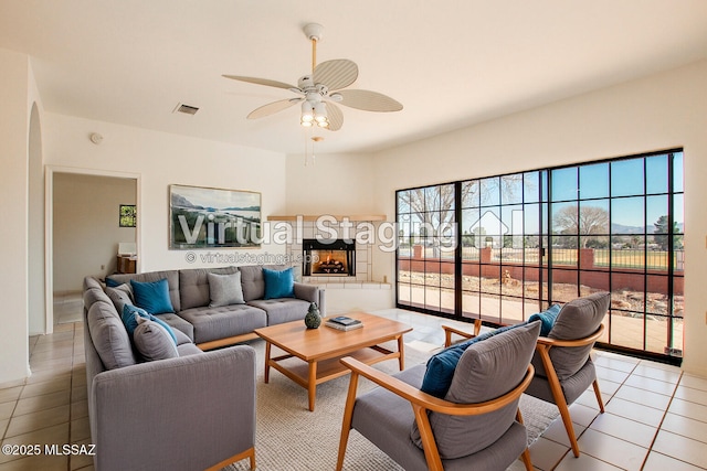 living room featuring light tile patterned floors and ceiling fan