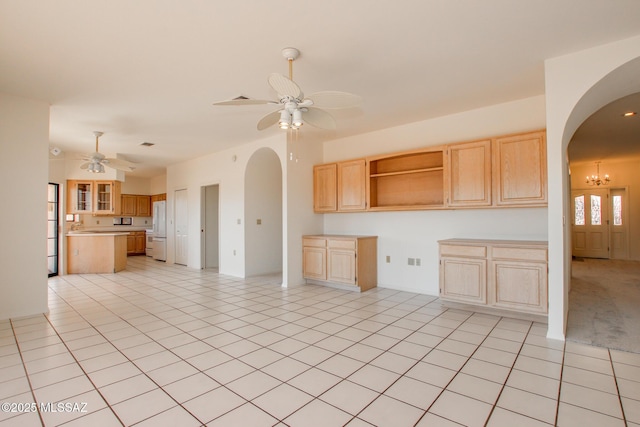 kitchen with ceiling fan with notable chandelier, light tile patterned flooring, white refrigerator, and light brown cabinetry