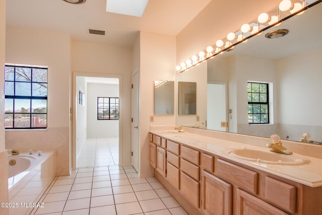 bathroom with tile patterned flooring, a skylight, and a wealth of natural light