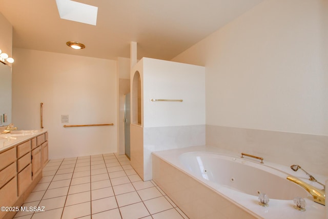 bathroom with tile patterned floors, vanity, a relaxing tiled tub, and a skylight