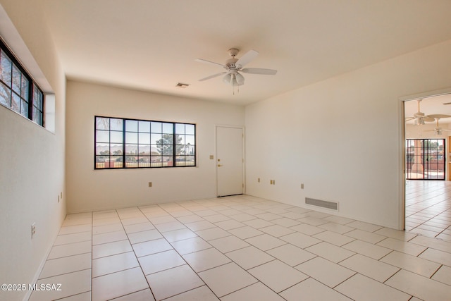 empty room with ceiling fan and light tile patterned flooring