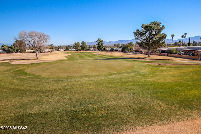 surrounding community with a mountain view and a yard