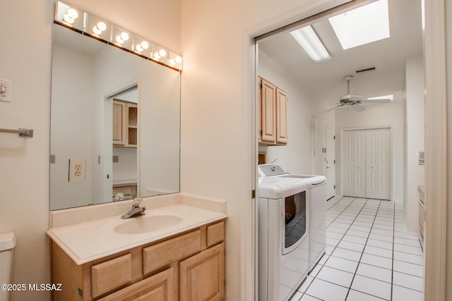 bathroom with a skylight, ceiling fan, separate washer and dryer, tile patterned floors, and vanity