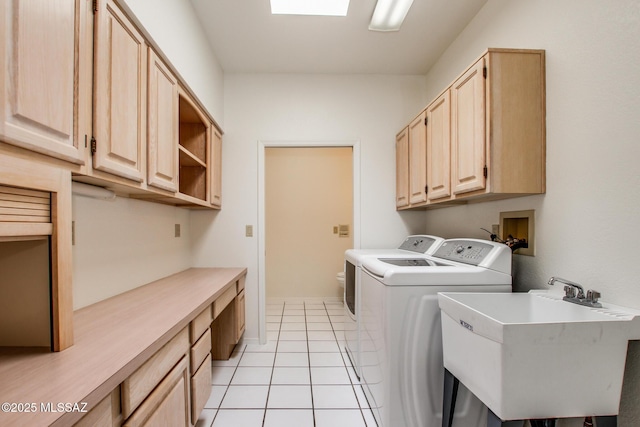 laundry area with washer and dryer, light tile patterned flooring, cabinets, and sink