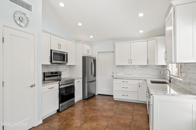 kitchen featuring sink, white cabinetry, appliances with stainless steel finishes, and tasteful backsplash