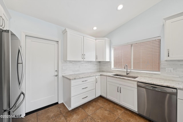 kitchen with light stone counters, sink, white cabinetry, and appliances with stainless steel finishes