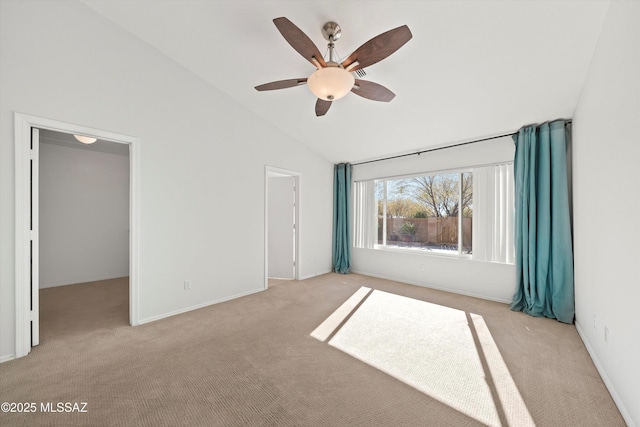 carpeted empty room with high vaulted ceiling and ceiling fan