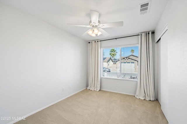 carpeted empty room featuring ceiling fan