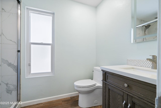 bathroom featuring vanity, toilet, and a shower with door