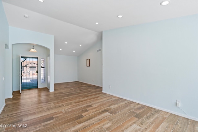 empty room with light hardwood / wood-style floors and lofted ceiling