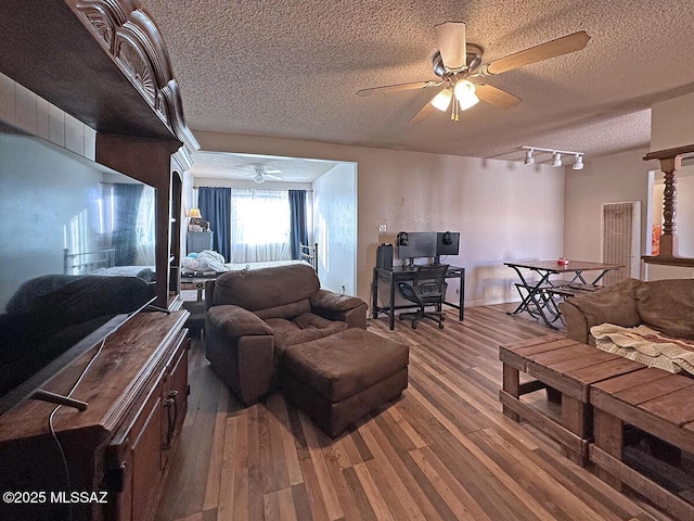 living room featuring a textured ceiling, ceiling fan, hardwood / wood-style floors, and track lighting