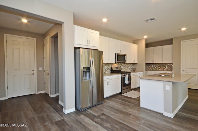 kitchen with dark hardwood / wood-style floors, sink, a kitchen island with sink, appliances with stainless steel finishes, and white cabinets