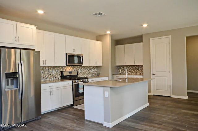 kitchen with white cabinetry, stainless steel appliances, a center island with sink, and sink