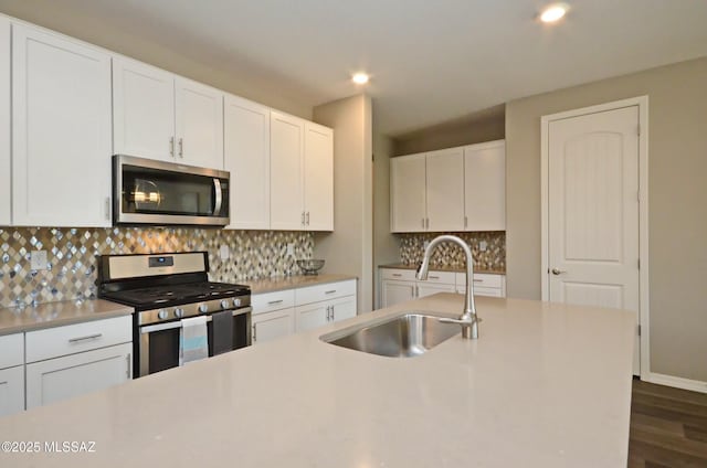 kitchen with sink, white cabinets, stainless steel appliances, and tasteful backsplash