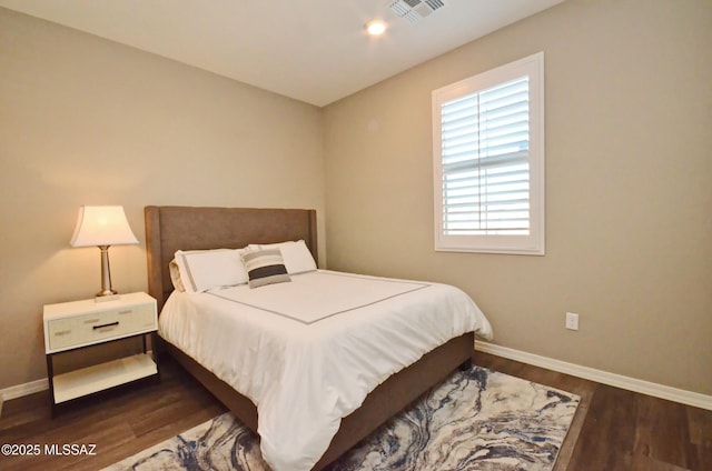 bedroom with dark hardwood / wood-style flooring