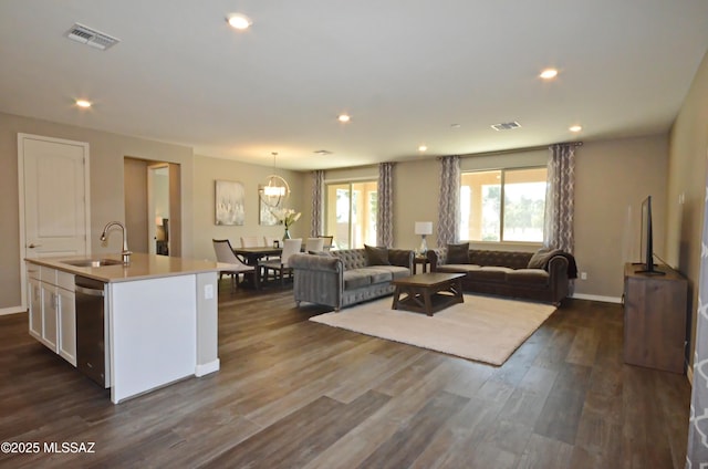 living room featuring dark hardwood / wood-style floors, sink, and an inviting chandelier