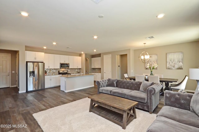 living room featuring dark hardwood / wood-style flooring and a notable chandelier