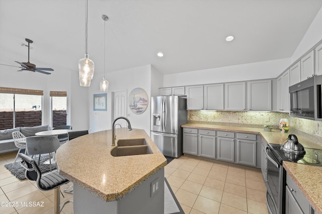 kitchen with a center island with sink, appliances with stainless steel finishes, gray cabinetry, decorative backsplash, and sink