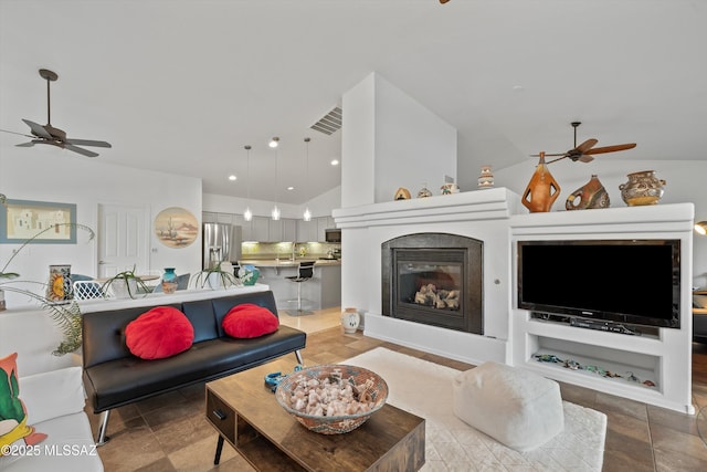 living room featuring vaulted ceiling, built in features, and sink