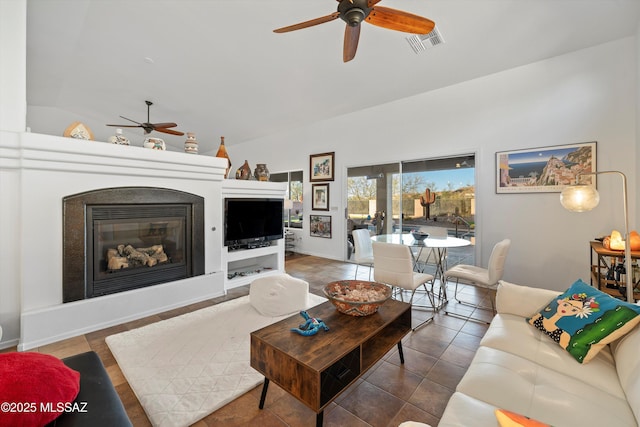 living room featuring vaulted ceiling, ceiling fan, and tile patterned flooring