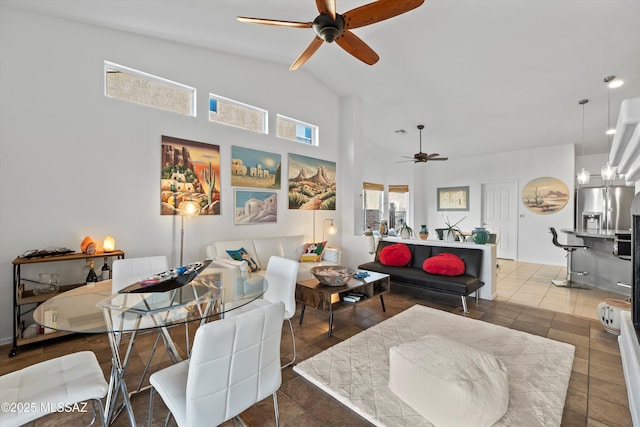 living room with ceiling fan, dark tile patterned flooring, and vaulted ceiling