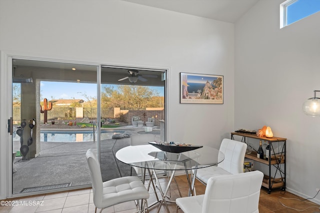 tiled dining space with ceiling fan and lofted ceiling