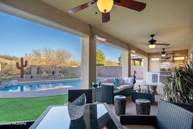 view of patio / terrace featuring exterior kitchen, outdoor lounge area, a fenced in pool, and ceiling fan