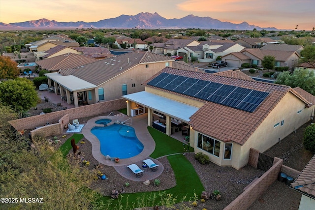 pool at dusk with a mountain view and a patio