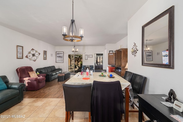 dining space featuring light tile patterned flooring and a chandelier