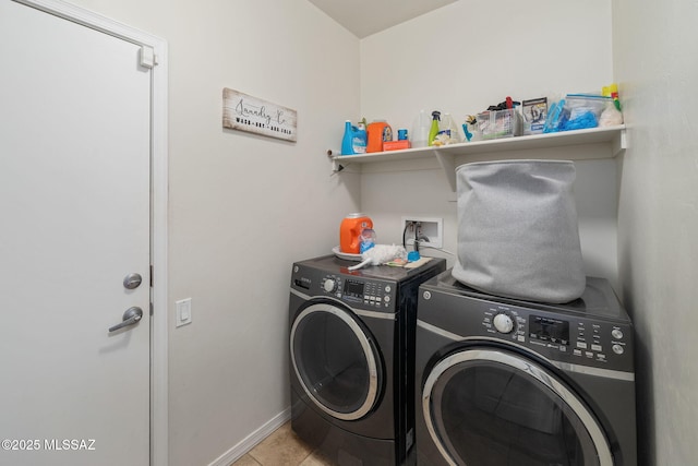 clothes washing area featuring washer and clothes dryer and light tile patterned floors