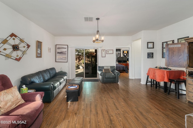 living room featuring a chandelier and dark hardwood / wood-style flooring