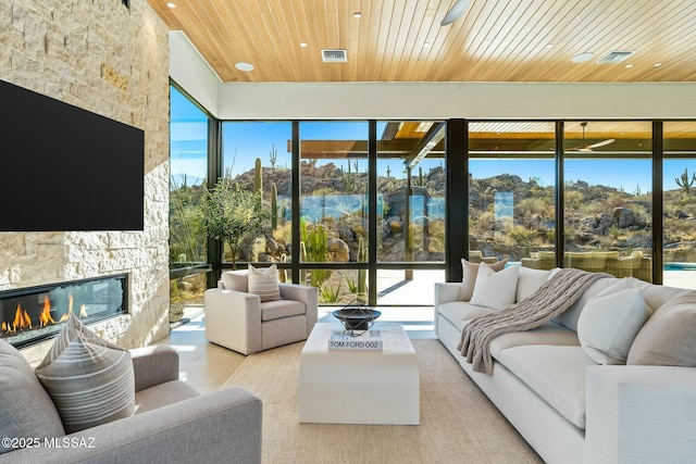 sunroom with wood ceiling and a fireplace