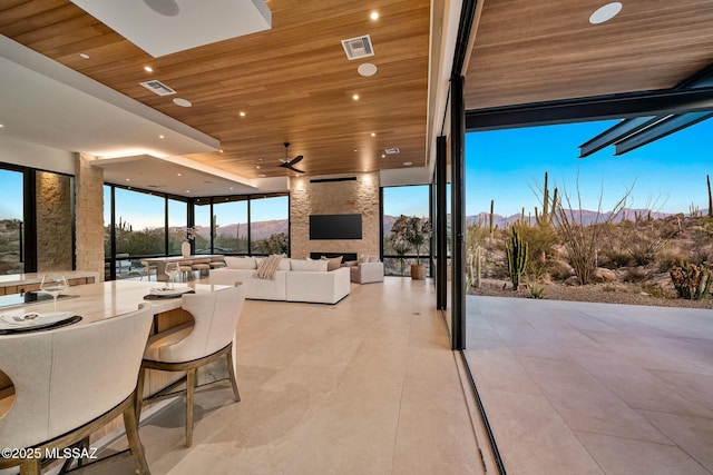 view of patio featuring ceiling fan and a large fireplace