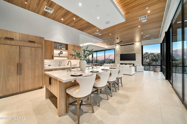 kitchen with a spacious island, tasteful backsplash, wood ceiling, and a breakfast bar area