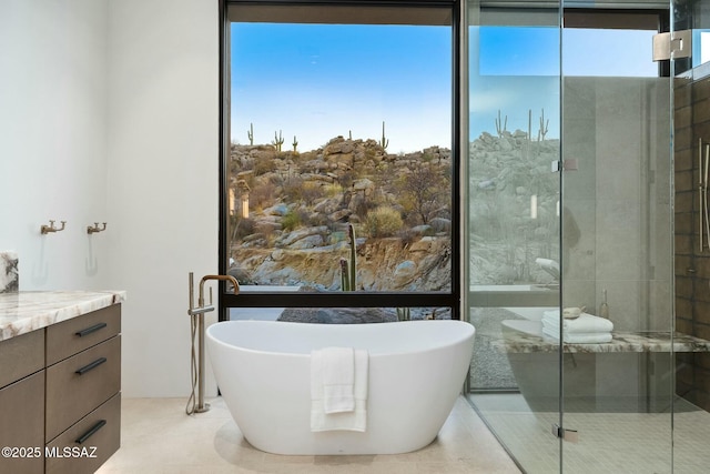 bathroom with vanity, expansive windows, and separate shower and tub