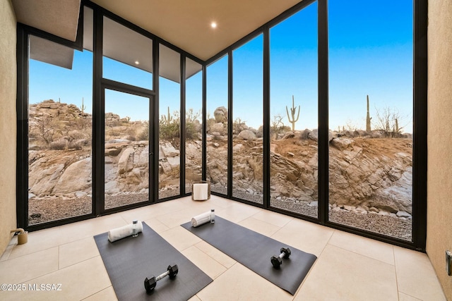 workout area with a wall of windows and light tile patterned flooring