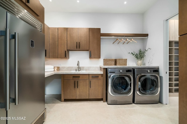 clothes washing area featuring cabinets, independent washer and dryer, sink, and light tile patterned floors