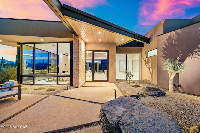 back house at dusk with a patio