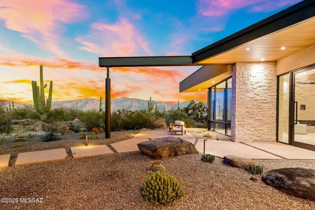 yard at dusk with a mountain view and a patio area