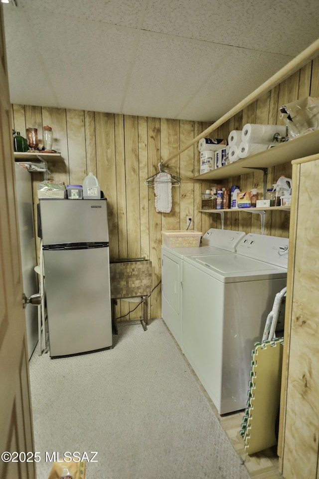 laundry area featuring washer and clothes dryer and wood walls