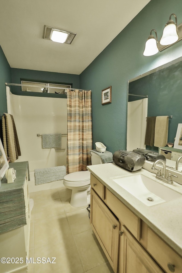 bathroom with tile patterned floors, vanity, toilet, and walk in shower